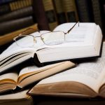 glasses on the open book in the library