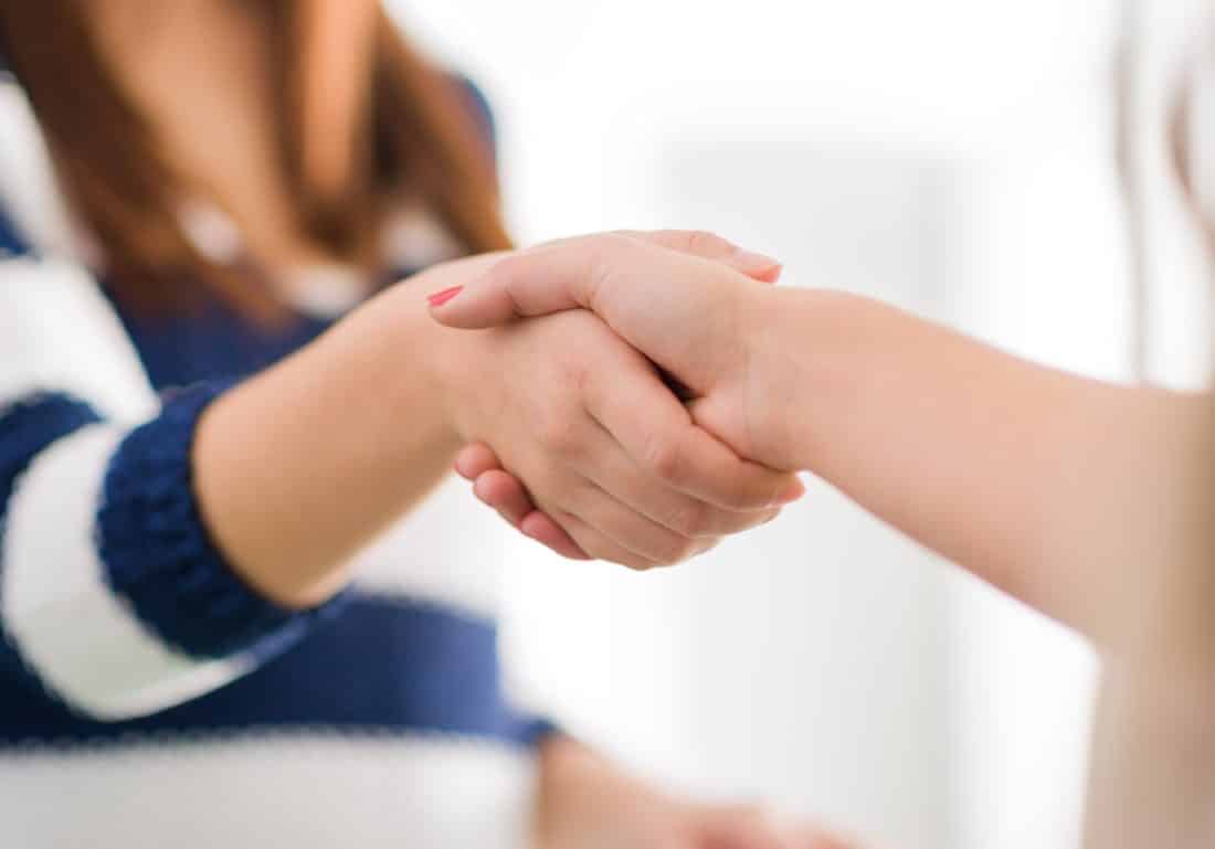 two women shaking hands