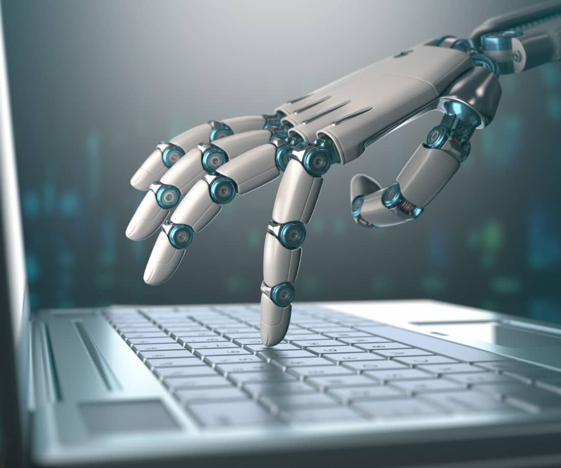 Artificial Intelligence robot hand on computer keyboard